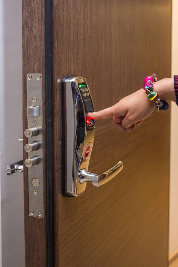 A hand using fingerprint access on a digital security door lock, enhancing safety.